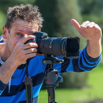 Photographie d'un élève avec son appareil photographique posé sur un monopode pendant un des cours particulier de photographie. alain pons photograph