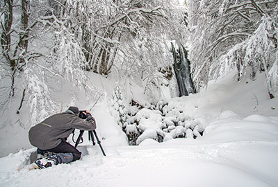 photographe photographiant la cascade de pérouse sous la neige en vallée de Chaudefour Auvergne